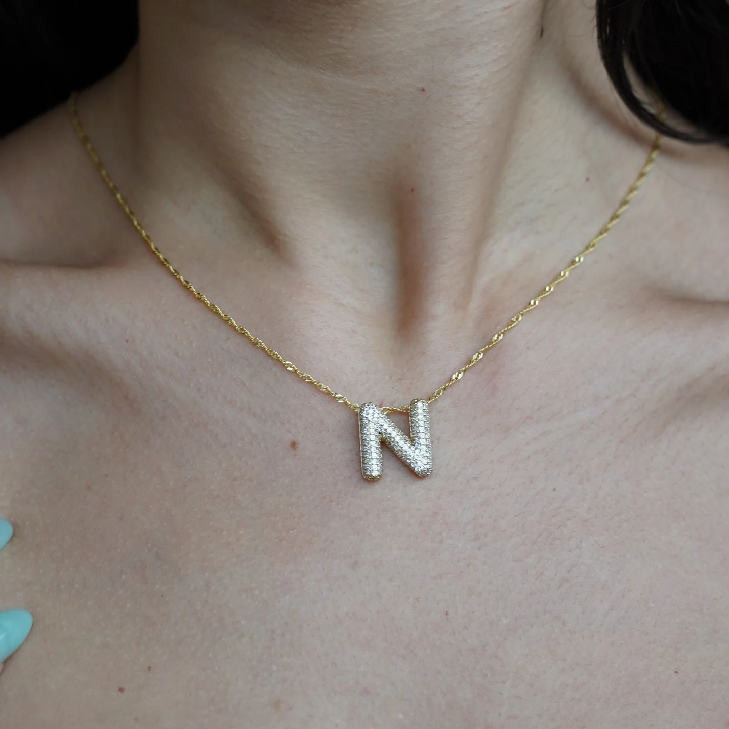 The N pendant in yellow gold, worn on the 18-inch Singapore chain